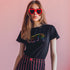 Election 2024 t-shirt with "VOTE" printed in large, colorful letters. Each letter features a different color from the rainbow spectrum, styled in a groovy 70s-inspired font.